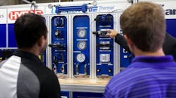 People listen to a demonstration on one of four brand-new hydraulic training stands. The training assemblies, valued at $30,000 per unit, will be used by students in Cincinnati State&rsquo;s Electro-Mechanical Engineering Technologies program to build modern manufacturing skills.