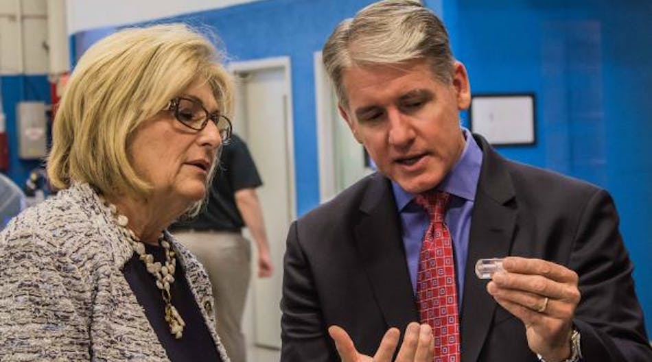 Des-Case President and CEO, Brian Gleason explains to U.S. Tennessee State Representative, Diane Black how a Des-Case-produced visual oil analysis can be glass-mounted onto the side of equipment to help technicians monitor lubricant quality.