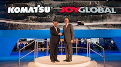 Ted Ohashi (left) and Ted Doheny shake hands over the acquisition of Joy Global by Komatsu.