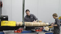 Workers make repairs using Price Engineering&apos;s hydraulic cylinder repair bench.