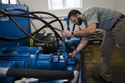 A technician at a test center checks seals and connections. A technician at a test center checks seals and connections.
