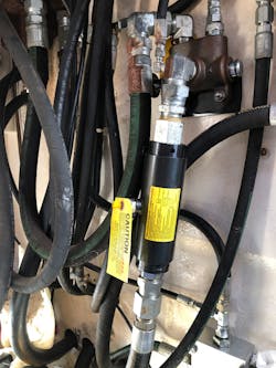 The suppressor from Wilkes & McLean (the black cylinder with a yellow label) is bidirectional and does not restrict fluid flow. The suppressor from Wilkes & McLean (the black cylinder with a yellow label) is bidirectional and does not restrict fluid flow.