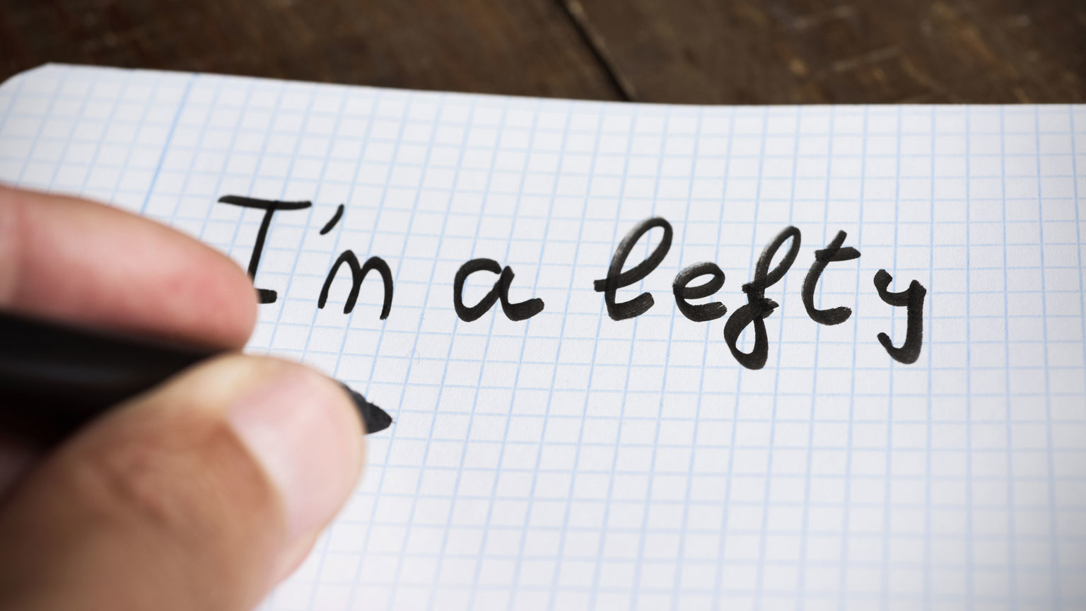 Closeup of a hand writing 'I'm a lefty'