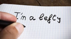 Closeup of a hand writing "I'm a lefty"