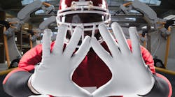 Football player holding out hands over background photo of robotic arms