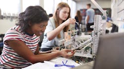 Students building a machine in an engineering class. Students building a machine in an engineering class.