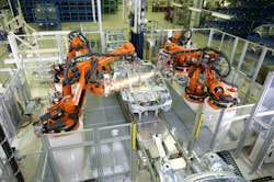 The Kuka robots are performing a welding operation with robotic weld guns. They are using electromechanical actuation to perform the various welds need on the car chassis.