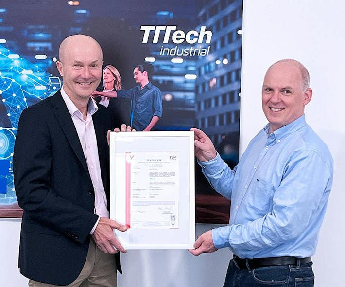 Alexander Zeppelzauer, Managing Director of T&Uuml;V Austria (left) hands the IEC 62443-4-1 certificate to Erwan Sudrat, Director of Development IoT at TTTech Industrial, who managed the certification project at TTTech Industrial (right), at the company&apos;s headquarters in Vienna.