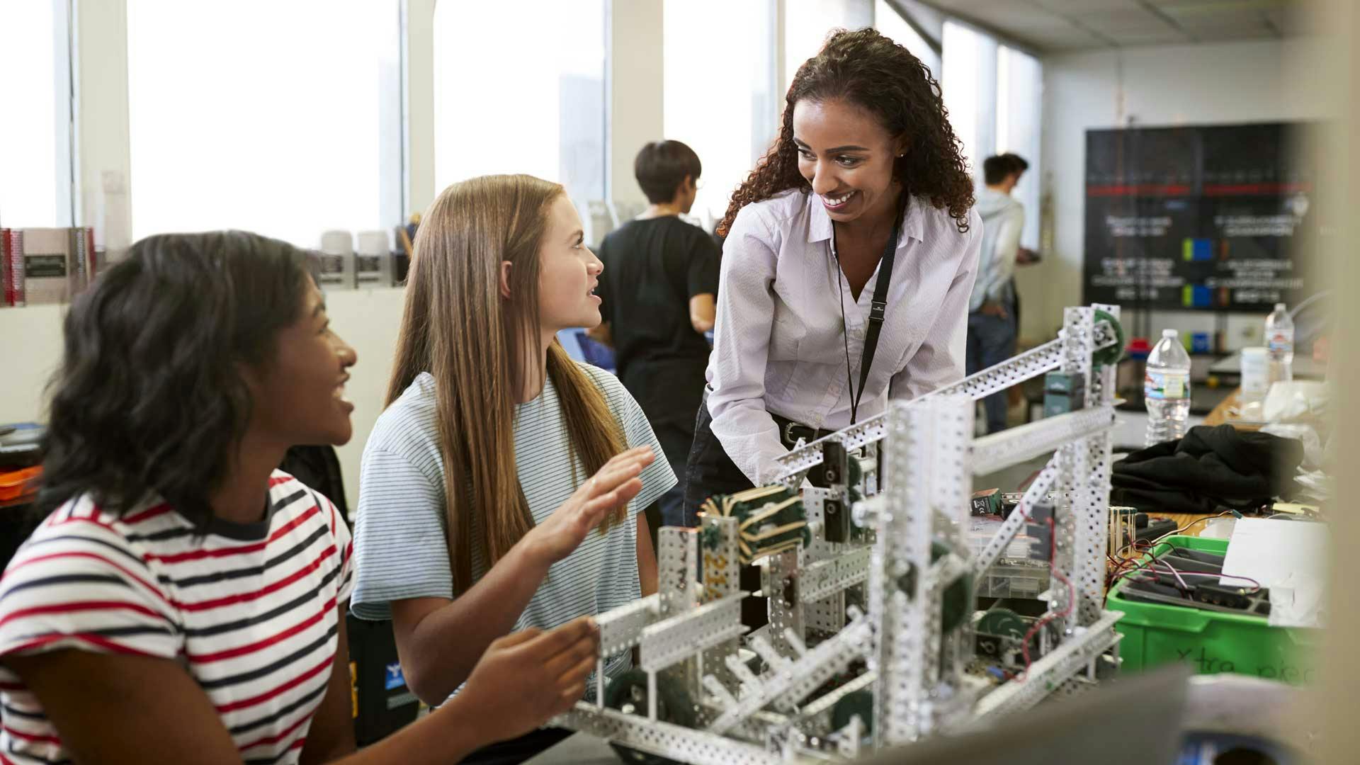 woman teaching female students in engineering class