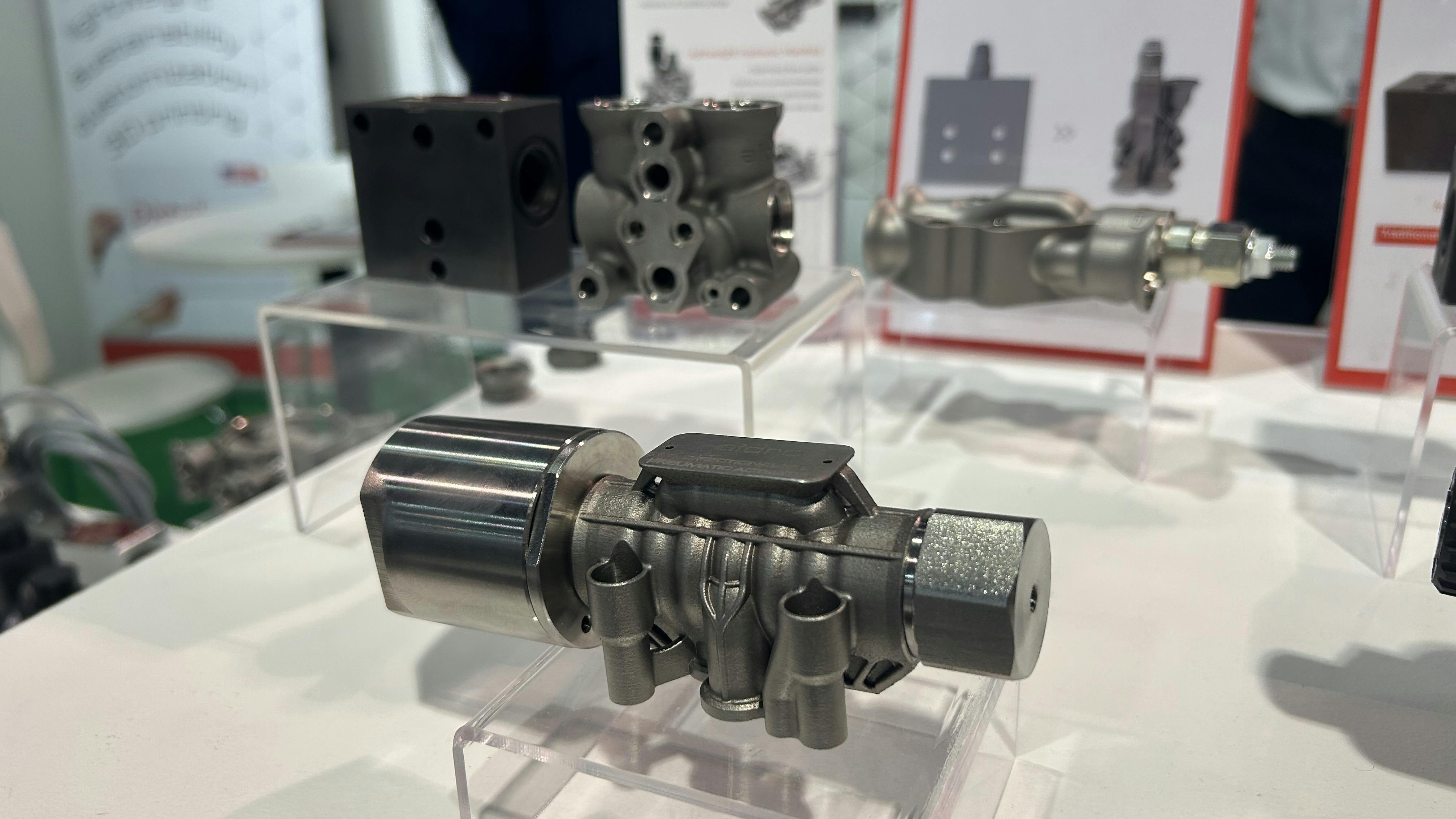 A 3D printed hydraulic component on display at a tradeshow demonstrates advancements in fluid power designs