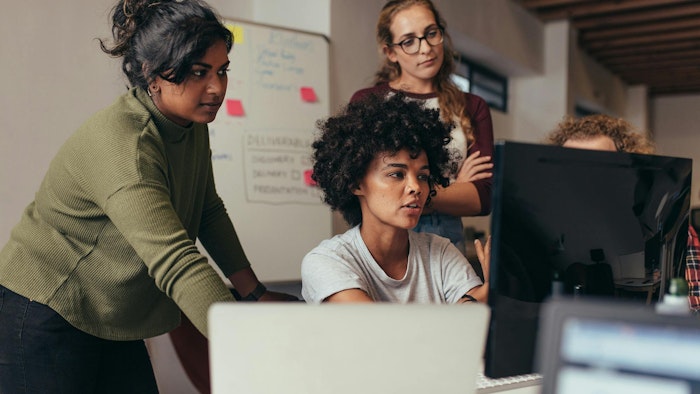 A group of female engineers working together at a computer