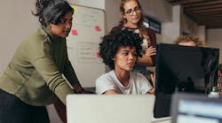 A group of female engineers working together at a computer A group of female engineers working together at a computer