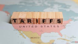 An image of wood blocks spelling out tariffs over a map of North America An image of wood blocks spelling out tariffs over a map of North America