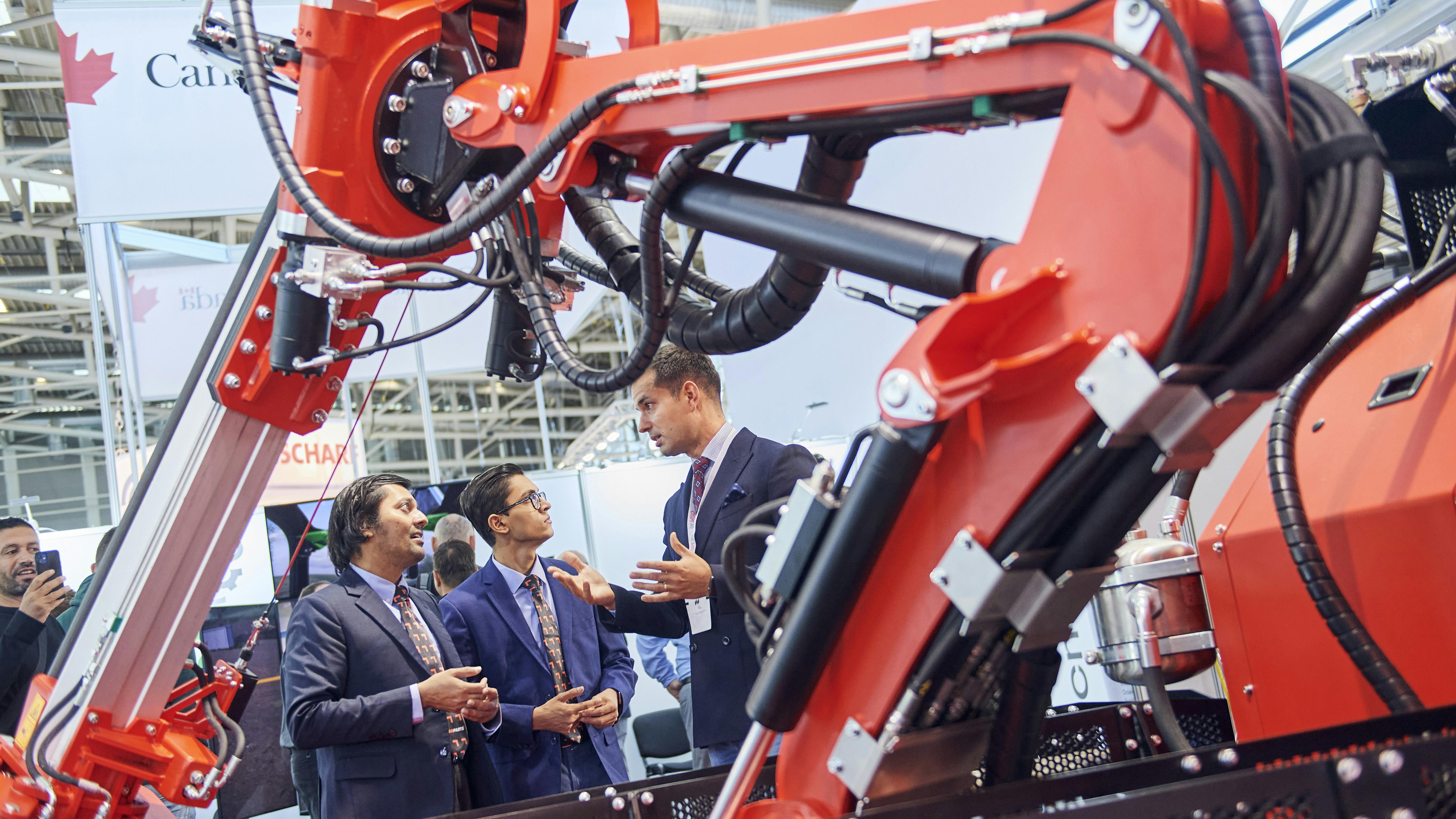 A close up view of hydraulic components on a construction machine on display at a trade show