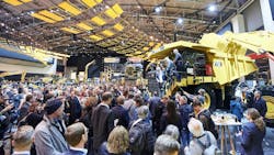 A crowd of tradeshow attendees standing around and looking at a mine haul truck A crowd of tradeshow attendees standing around and looking at a mine haul truck