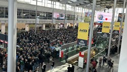 An image of a crowd of people lined up to enter a trade show An image of a crowd of people lined up to enter a trade show
