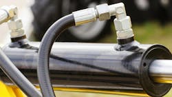 A close up view of a hydraulic cylinder and hoses connected to it A close up view of a hydraulic cylinder and hoses connected to it
