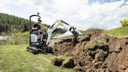 The Bobcat E10e electric mini excavator digging dirt on a job site The Bobcat E10e electric mini excavator digging dirt on a job site