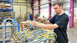 A man works on a system assembly of hoses and cylinders A man works on a system assembly of hoses and cylinders
