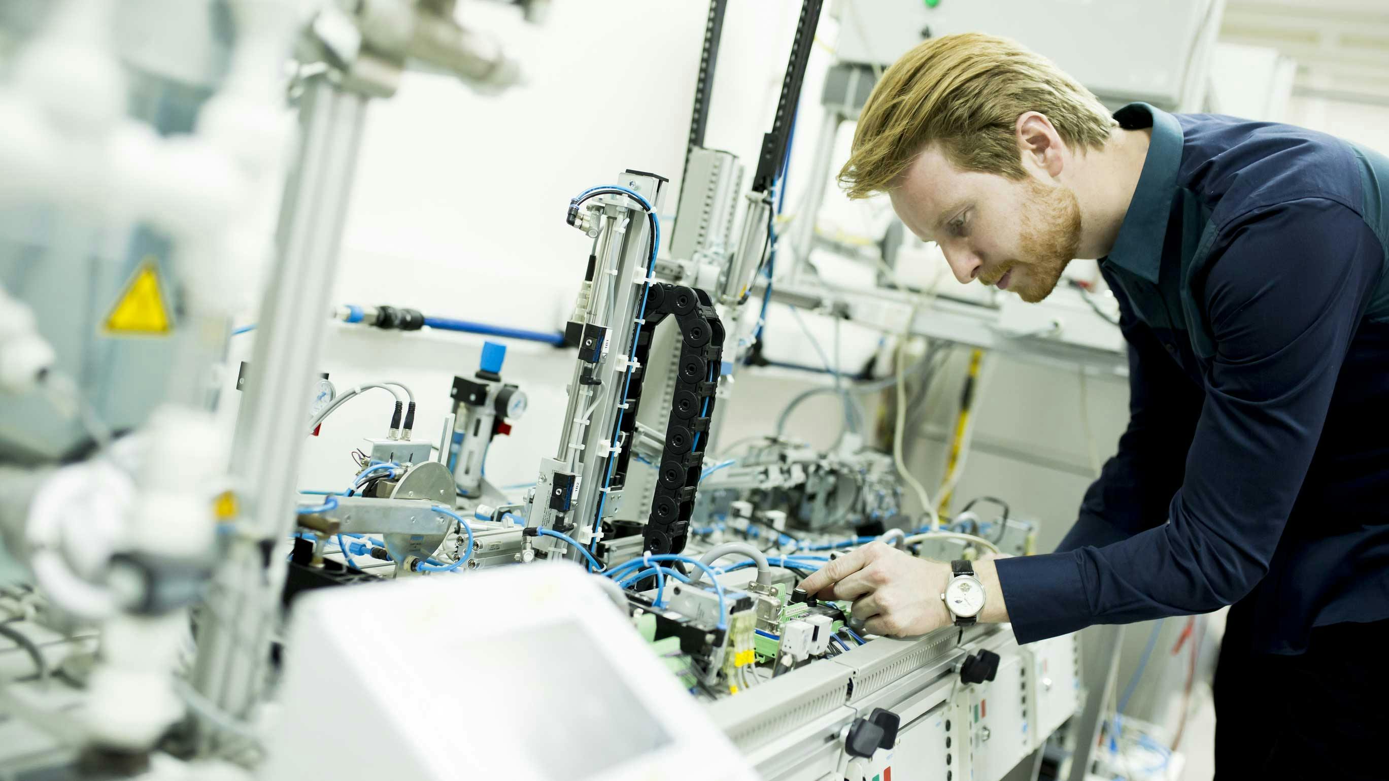 A man evaluates components in a manufacturing facility