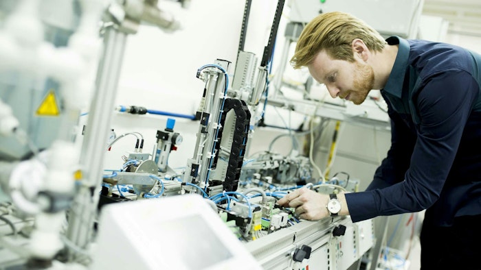A man evaluates components in a manufacturing facility