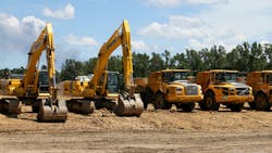 Excavators and articulated haulers lined up on a construction job site Excavators and articulated haulers lined up on a construction job site