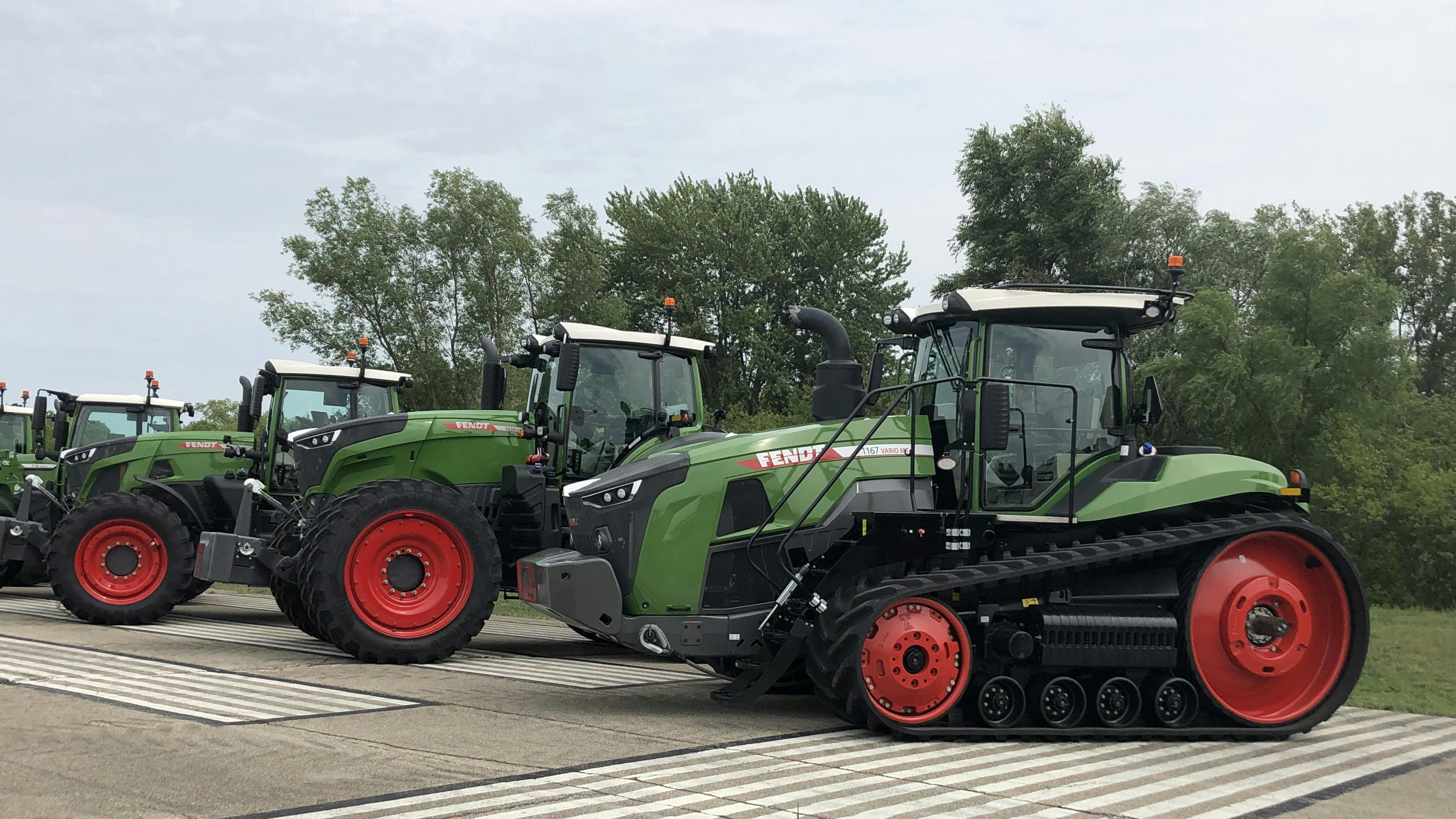 Several models of tractors from AGCO's Fendt brand lined up next to one another