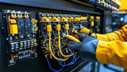 A worker wears high voltage gloves while working with an electric system A worker wears high voltage gloves while working with an electric system