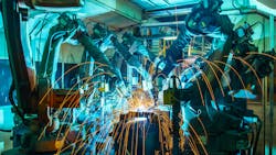 Welding robots working in an automotive manufacturing facility Welding robots working in an automotive manufacturing facility