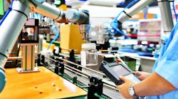 A cobot picking up a glass bottle with a human worker observing A cobot picking up a glass bottle with a human worker observing