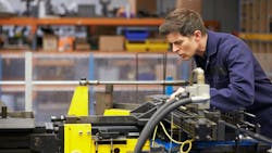 A factory engineer working with a hydraulic tube bender A factory engineer working with a hydraulic tube bender