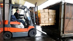 A forklift moving boxes into a truck A forklift moving boxes into a truck