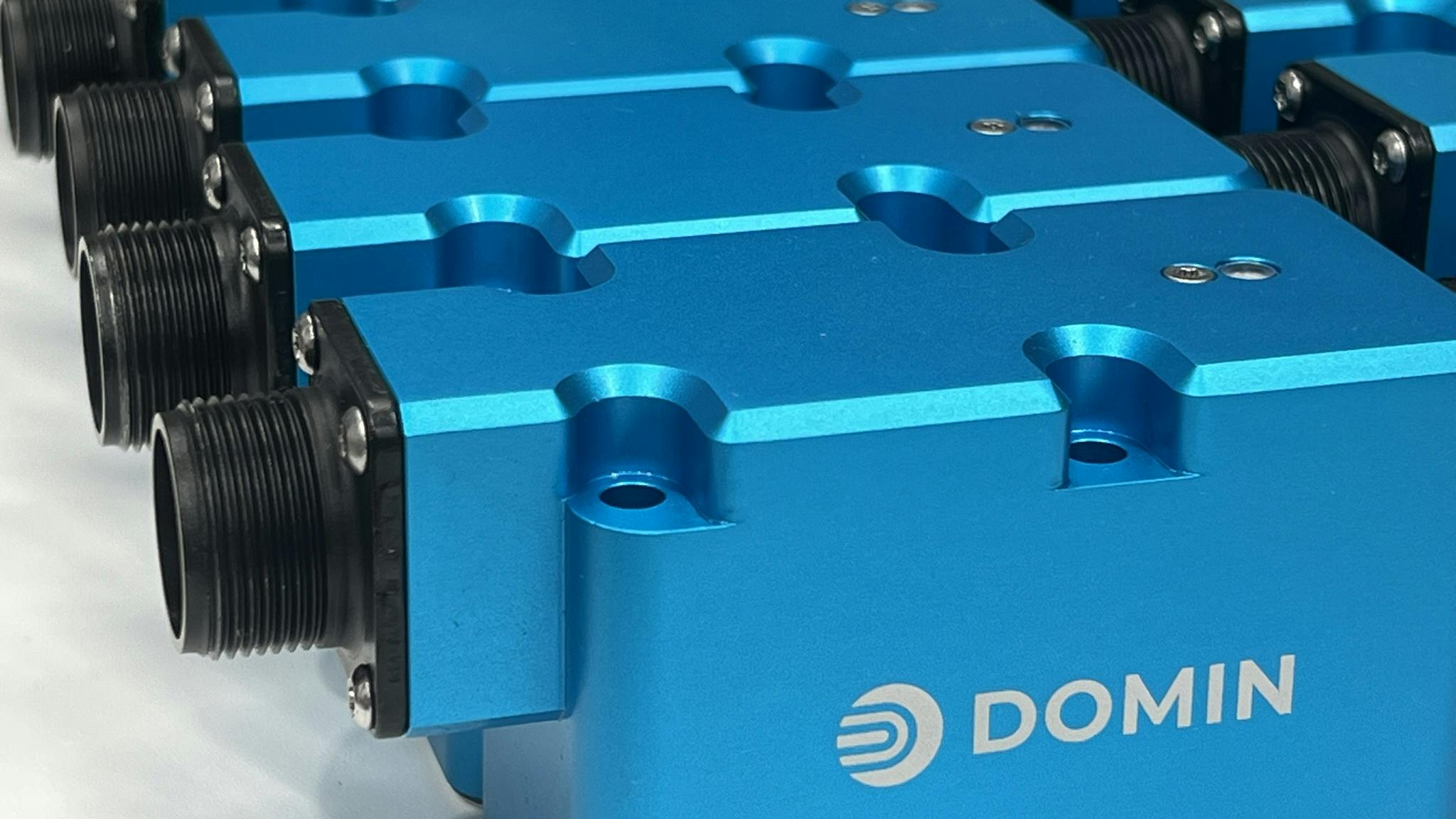 Several Domin hydraulic servo valves lined up next to each other