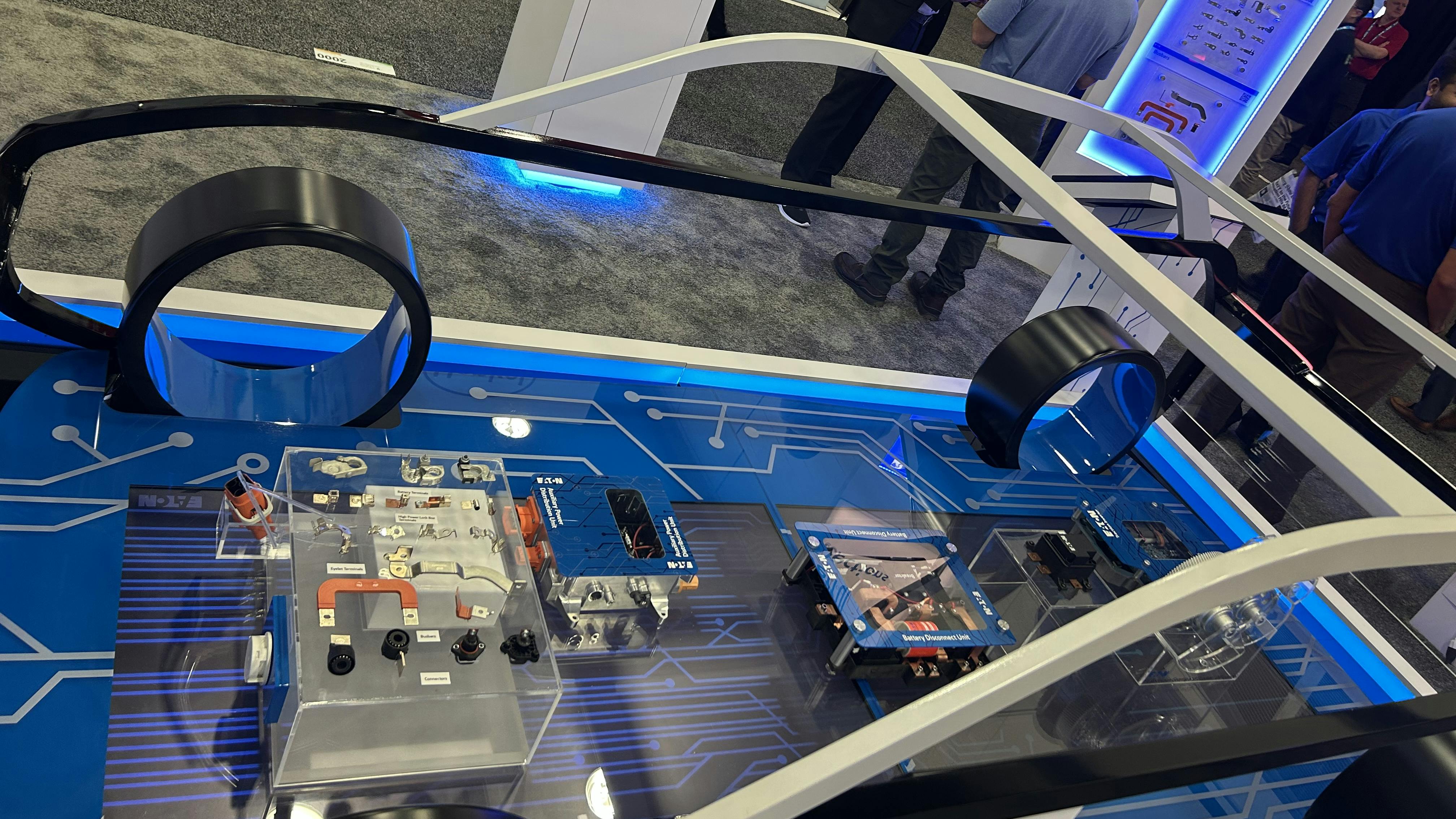 Various electric vehicle components in a see-through car display at The Battery Show 2025
