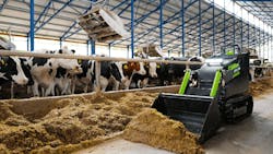 FIRSTGREEN Industries MiniZ electric tracked loader operating in a barn near animals FIRSTGREEN Industries MiniZ electric tracked loader operating in a barn near animals