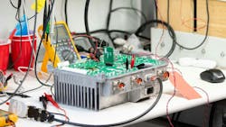 A battery in a testing laboratory with wires and testing equipment hooked up to it A battery in a testing laboratory with wires and testing equipment hooked up to it