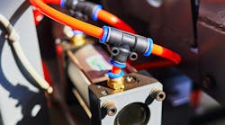 Pneumatic cylinder and tubing installed on an industrial machine Pneumatic cylinder and tubing installed on an industrial machine