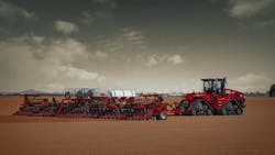CNH planter being pulled by a tractor through a field CNH planter being pulled by a tractor through a field