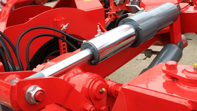 Close up on a hydraulic cylinder and other fluid power components on a machine