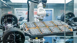 Manufacturing display featuring robotic arms assembling lithium-ion EV battery pack Manufacturing display featuring robotic arms assembling lithium-ion EV battery pack
