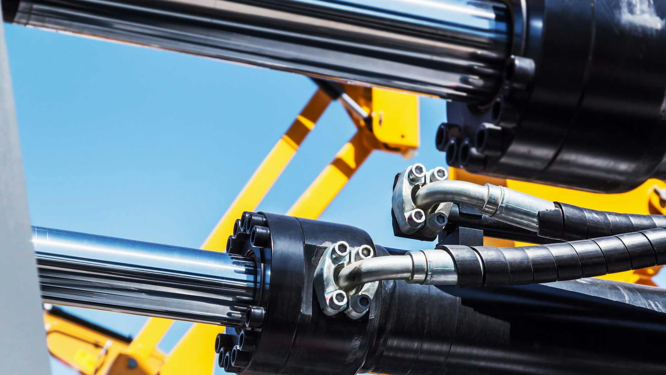 Close up view on hydraulic cylinders and hoses on a machine