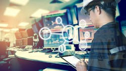 Technician looking at tablet with icons depicting industrial digital tools for uptime Technician looking at tablet with icons depicting industrial digital tools for uptime