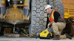 A man using the Enerpac XC2 Battery Hydraulic Pump and Jack to lift up a piece of construction equipment A man using the Enerpac XC2 Battery Hydraulic Pump and Jack to lift up a piece of construction equipment
