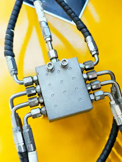 Hydraulic manifold and hoses connected to it on a yellow machine Hydraulic manifold and hoses connected to it on a yellow machine