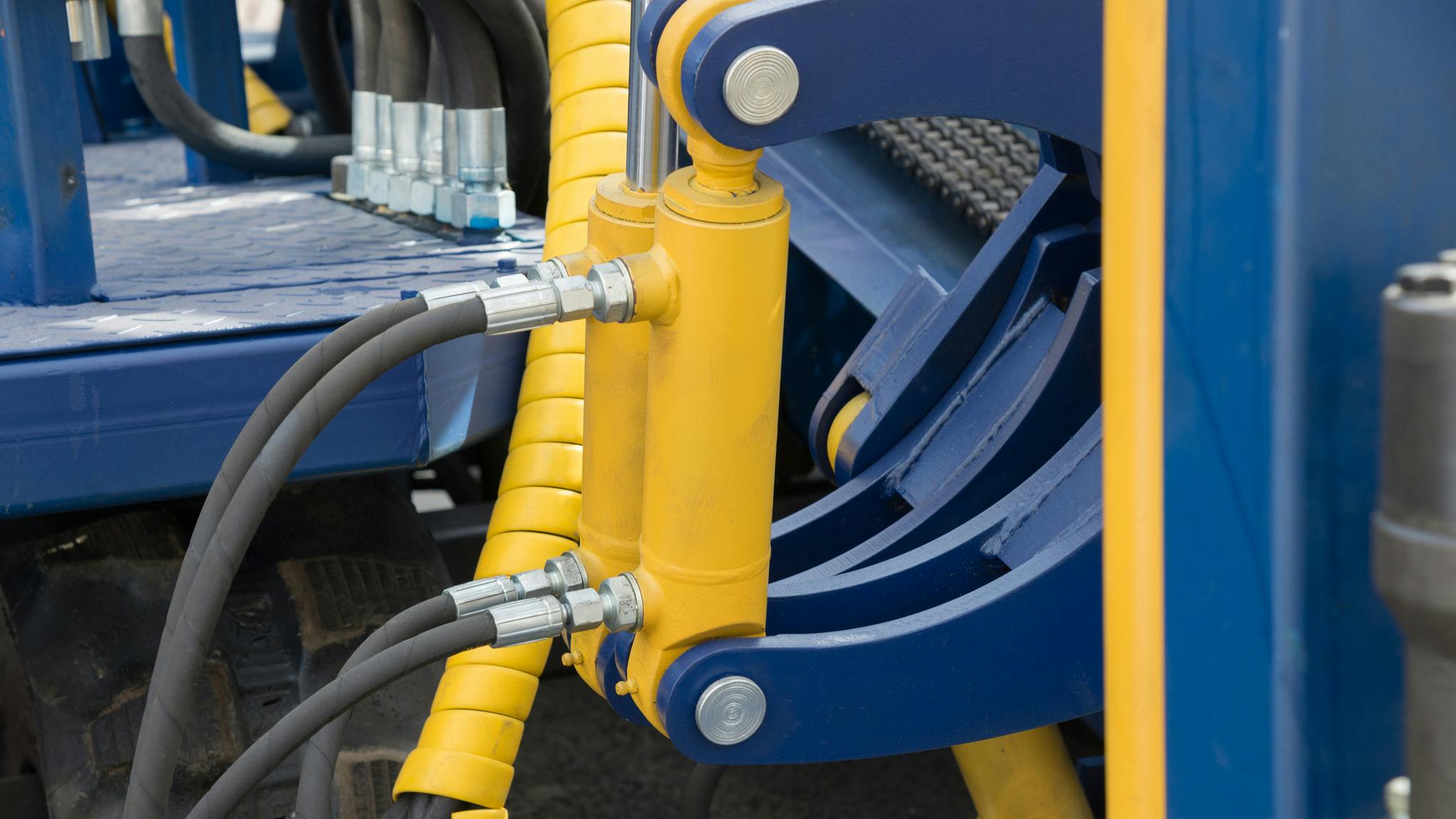Close up on hydraulic cylinders, hoses and other components on a machine