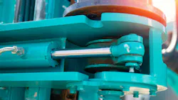 Close up on a hydraulic cylinder on a blue machine