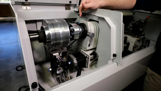 Hand pointing to the Tormach Automatic Collet Closer in a CNC Lathe