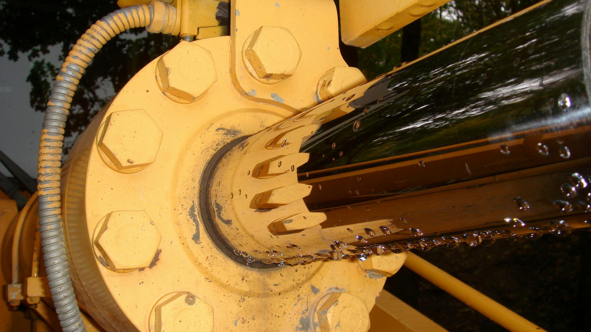 Close up view of a hydraulic cylinder on a yellow machine