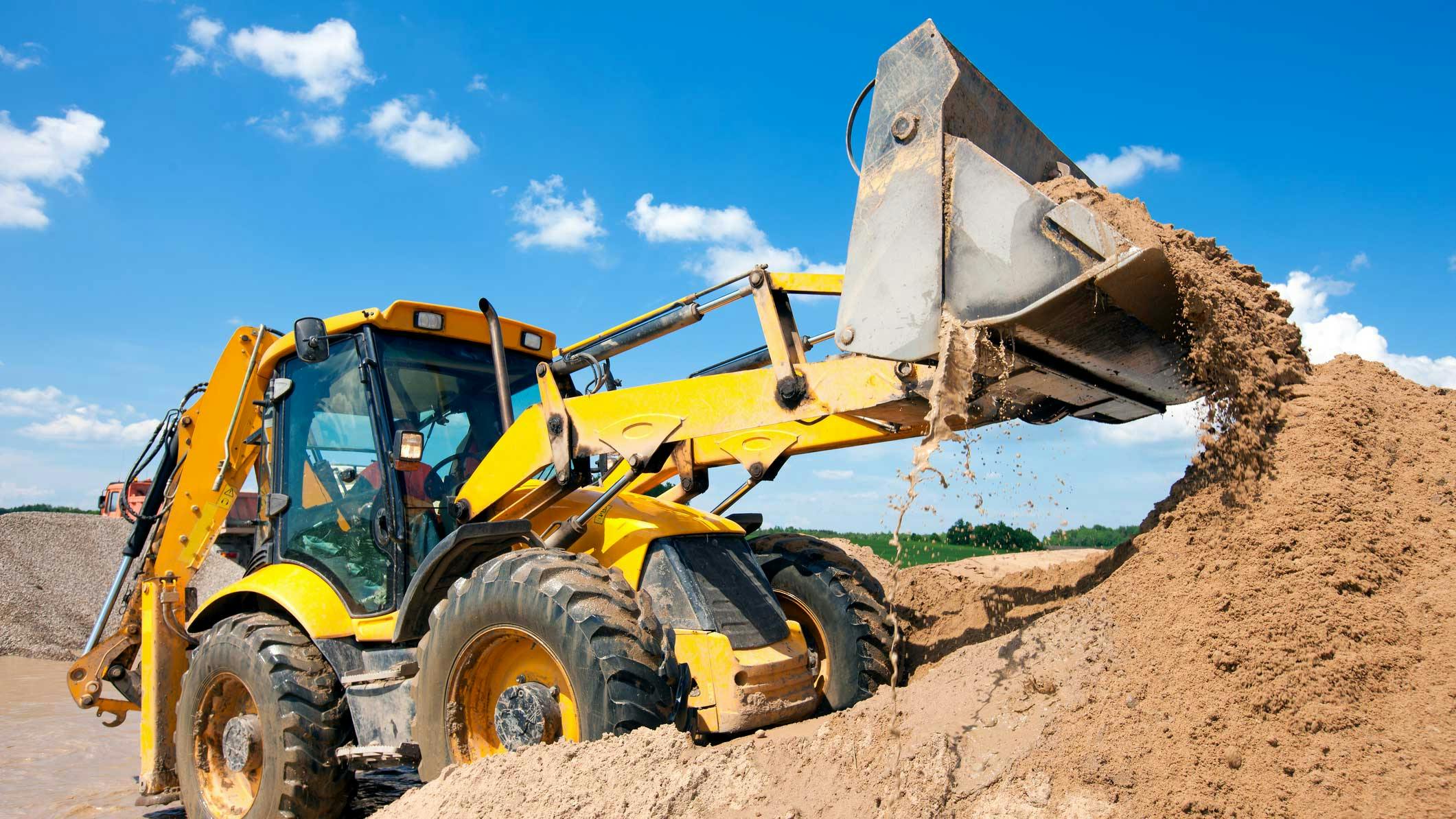 Backhoe digging in a pile of dirt