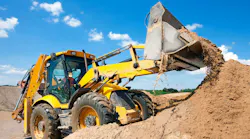 Backhoe digging in a pile of dirt